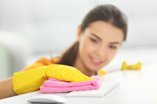 Office cleaners sanitizing desks and shared surfaces in Roehampton
